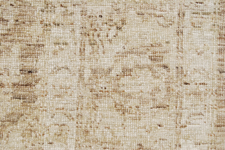 Authentic hand-knotted Afghan area rug from Ariana Rugs, featuring a muted Persian floral design in soft pale gold, light brown, and cream wool woven by Hazara women artisans.
