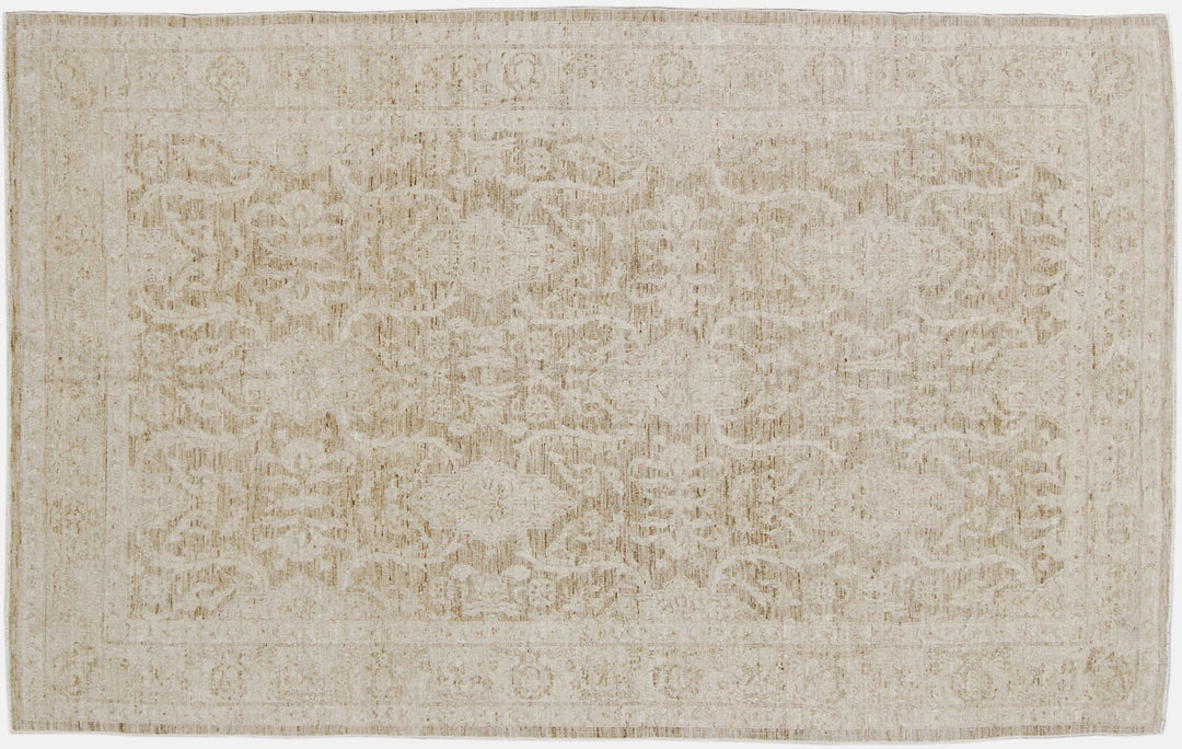 Authentic hand-knotted Afghan area rug from Ariana Rugs, featuring a muted Persian floral design in soft pale gold, light brown, and cream wool woven by Hazara women artisans.