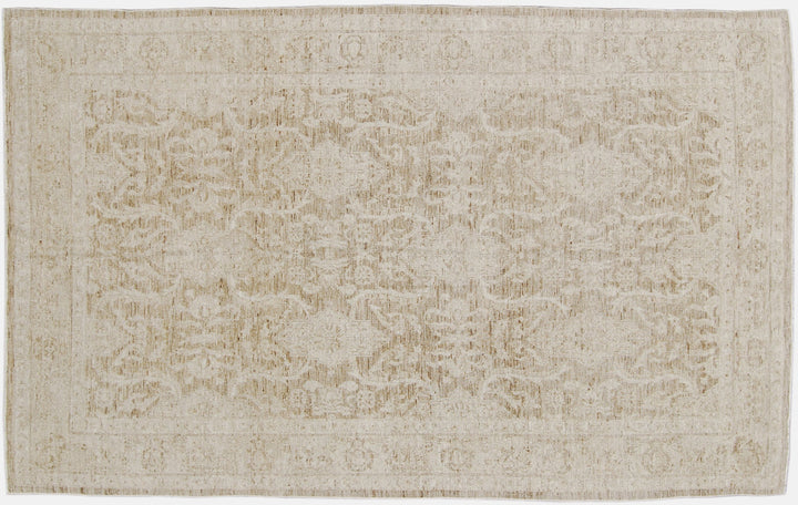 Authentic hand-knotted Afghan area rug from Ariana Rugs, featuring a muted Persian floral design in soft pale gold, light brown, and cream wool woven by Hazara women artisans.