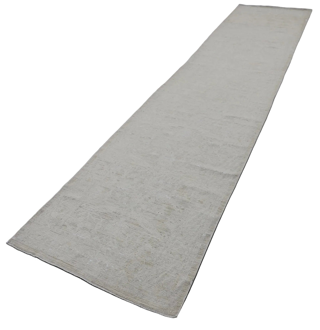 Authentic hand-knotted Afghan runner rug from the Ariana Vintage Collection, featuring a brand-new, beautifully distressed geometric design in pale, muted organic wool tones.