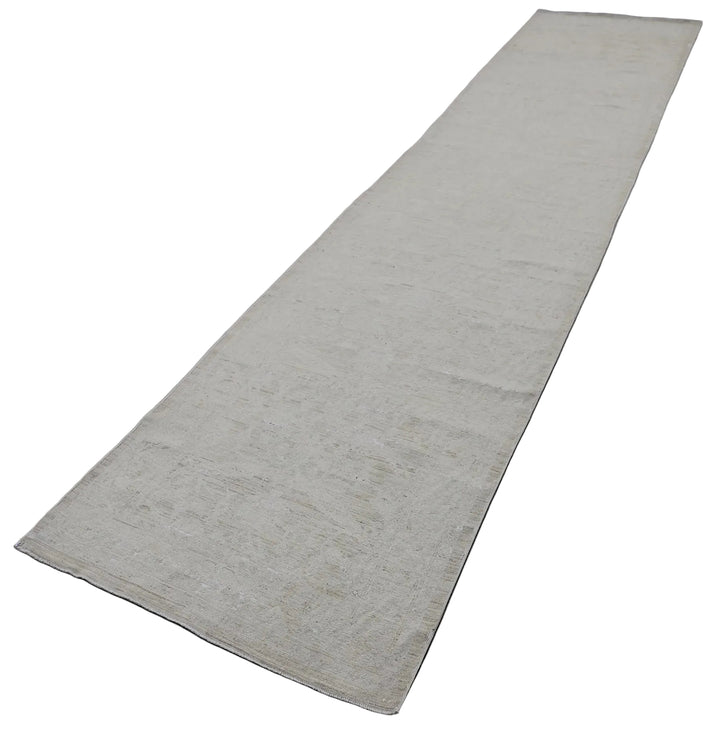 Authentic hand-knotted Afghan runner rug from the Ariana Vintage Collection, featuring a brand-new, beautifully distressed geometric design in pale, muted organic wool tones.