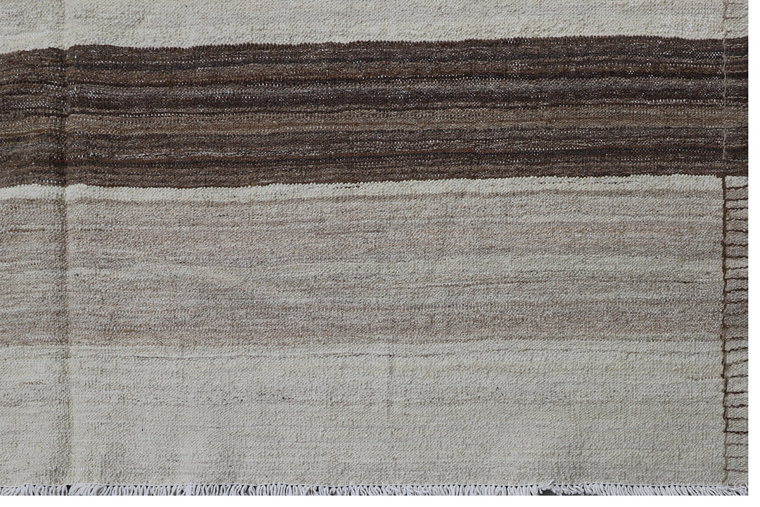 Contemporary living room styled with a 6x9 taupe, brown, and cream striped Afghan wool kilim from Ariana Rugs West Hollywood.