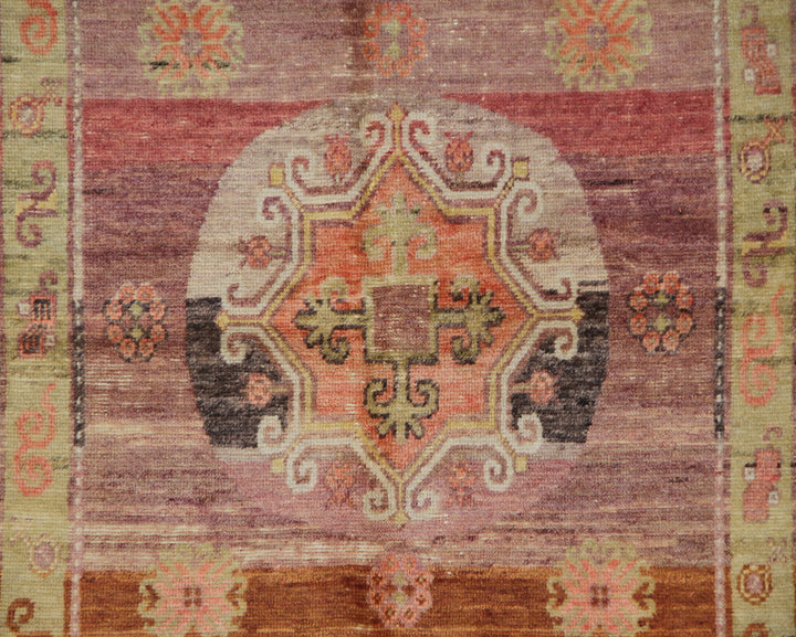 Vintage antique Samarkand Khotan hand-knotted wool runner measuring 7'11" x 3'9" featuring a geometric medallion design in purple, pink, reds, and mauve.