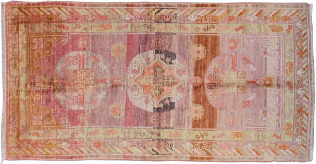 Vintage antique Samarkand Khotan hand-knotted wool runner measuring 7'11" x 3'9" featuring a geometric medallion design in purple, pink, reds, and mauve.