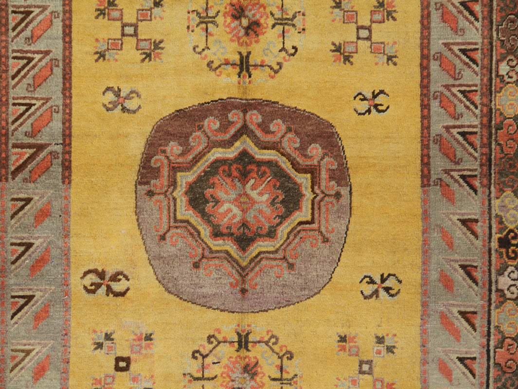 Rare antique hand-knotted Samarkand Khotan wool area rug featuring a central medallion on a unique luminous yellow field
